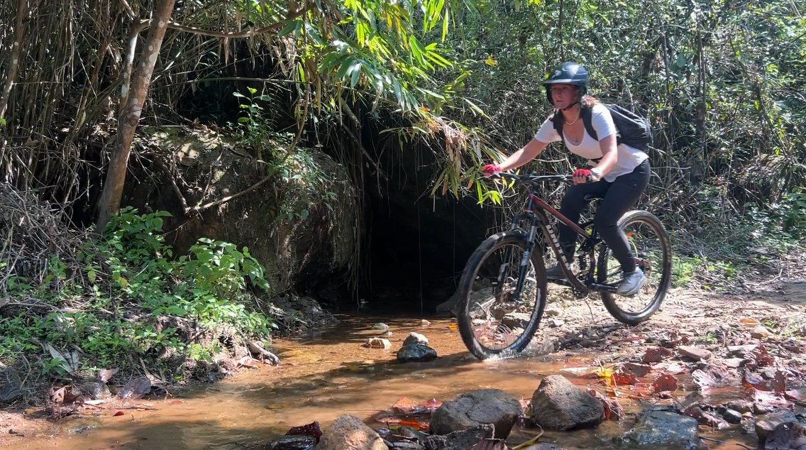 A rider crosses a shallow stream on the trail